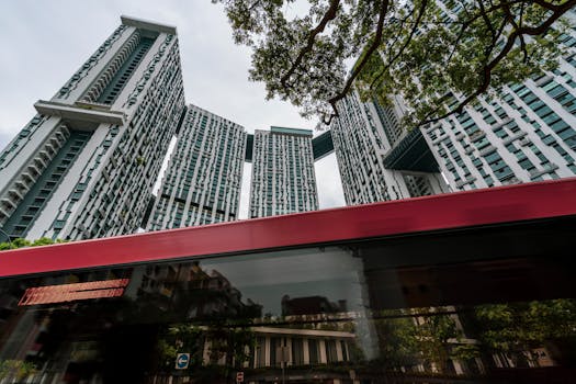 Dynamic cityscape of The Pinnacle Duxton skyscrapers with a passing bus in Singapore.
